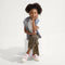 model | An alternate image of a child modeling The Kids Strap Sneaker in Pink Taffy. 
