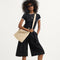 hover | The Mini Zip Bucket in Knot Brown, carried over the shoulder of a female model, shown from the front.
