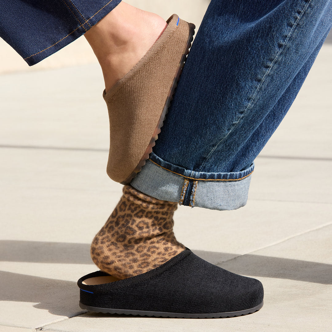 Person wearing leopard print socks with The Casual Clog in black.