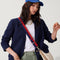 hover | The Crossbody Strap in Navy & Red, shown paired with The Crescent Bag, worn by a model, shown from the side