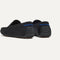 Close up of the heel of The Men's Driver in Black, with raised peg outsoles and Rothy's signature blue halo. 
