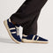 hover | Model wearing The Men's Court Sneaker in ReVelvet™ Deep Navy.
