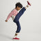 model | Alternate image of a child modeling The Kids Stretch Sneaker in Firecracker.